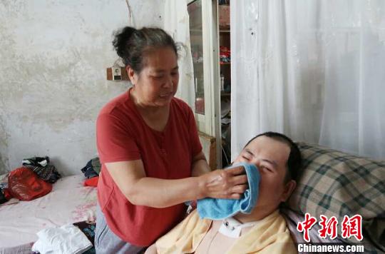 每次喂完食物后，梁青蘭都要仔細(xì)地幫兒子清理干凈?！∩忻鱾b 攝