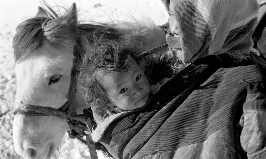 1990年3月，西藏當(dāng)雄縣納木湖鄉(xiāng)三村女牧民斯卓不畏嚴(yán)寒，懷抱幼子，準(zhǔn)備到遠(yuǎn)處放牧。新華社記者覺果攝