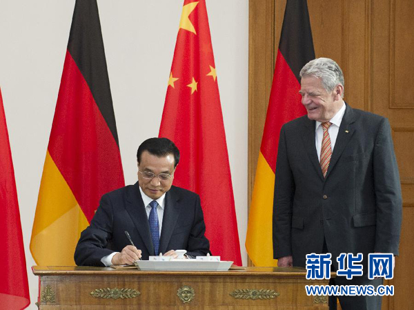 10月10日，國務(wù)院總理李克強在柏林會見德國總統(tǒng)高克。這是李克強總理在高克總統(tǒng)的陪同下在貴賓簿上簽字。 新華社記者 王曄 攝 